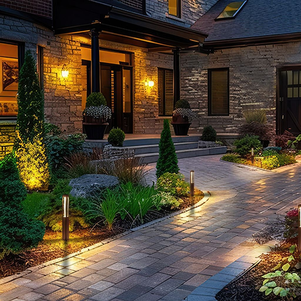 Aluminum path light scene with several fixtures along a house walkway, creating warm, even landscape illumination.